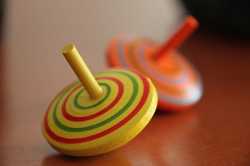 colorful peg tops on wooden background