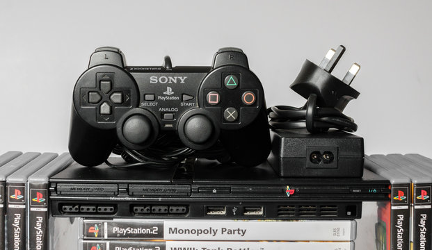 london, england, 07/05/2018 An original slim black sony playstation 2 console with games and controls. PS2 retro video game console. clean immaculate vintage console. Sonys game hardware unit isolated
