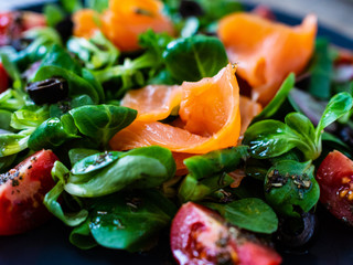 Salmon salad - smoked salmon and vegetables on wooden background
