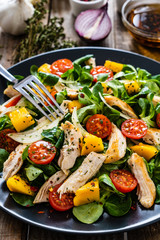 Caesar salad - fried chicken breast and vegetables on wooden table