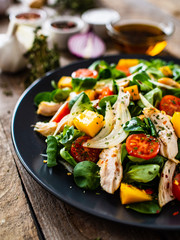Caesar salad - fried chicken breast and vegetables on wooden table