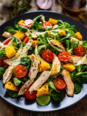 Caesar salad - fried chicken breast and vegetables on wooden table