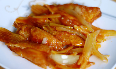 Sweet and Sour salmon fin on white plate. Indonesian food.