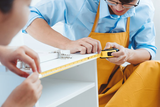 Happy Asian Couple Home Improvement Assembling Measuring The Furniture Moving Into New House Renovation Concept