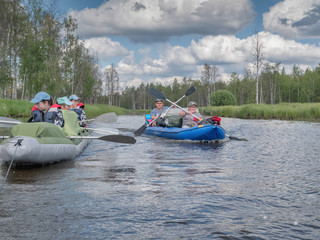 Fototapeta na wymiar Karelia, Vodlozero - 29.07.2019: Tourists in boats. Ecotourism, visiting fragile, undisturbed natural areas. Active extreme holidays. Water rafting in North lakes and rivers