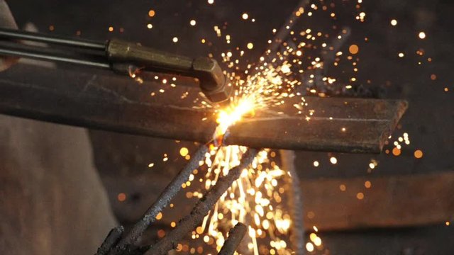 Welder worker with cutting gas to cut iron thick sheet.Gas plasma cutter is cutting to steel plate in the metal plant materials cut with a plasma torch include iron, steel, stainless steel, aluminum.