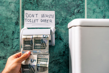 Panic metaphor with coronavirus toilet paper. Toilet paper with bills.