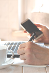 Freelancer works in the home office sitting at the desk near the window