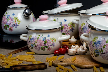A set of metal dishes surrounded by vegetables