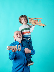 Portrait Grandpa and Grandson Playing with Toys Plane. Family Relationship Grandfather and Grandson. Male Family Concept. Positive Boy, Grandfather And Grandson isolated on Blue Background.