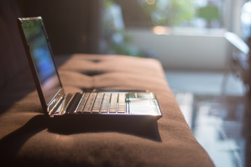 laptop  on sofa and sun light background