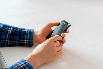 person's hands holding a crashed broken phone, mobile smartphone