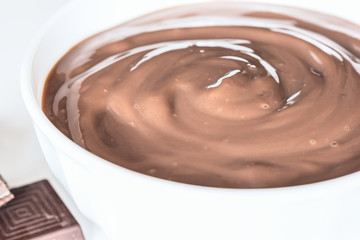 chocolate pudding in white bowl close-up. sweet dessert in the form of chocolate pudding in a ceramic bowl close-up.