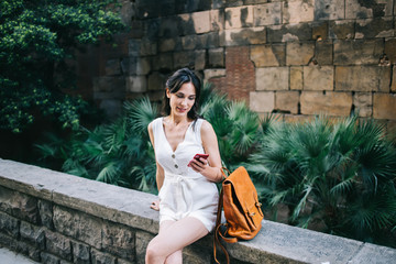 Smiling lady texting on cellphone in street