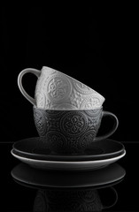 
Tea cups saucers on a black background