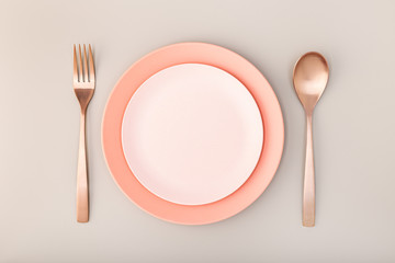 Empty Plate, fork and knife on Table. Pink Pastel tones. Mock up