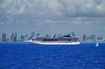 	 Huge modern MSC Cruises cruiseship or cruise ship liner MSC Divina at sea with skyline of Miami...