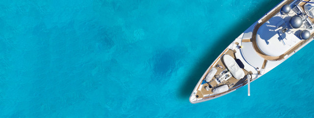 Aerial drone top down ultra wide photo with copy space of luxury yacht anchored in tropical exotic...