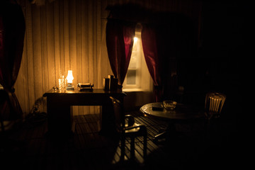 A realistic dollhouse living room with furniture and window at night. Artwork table decoration with handmade realistic dollhouse.