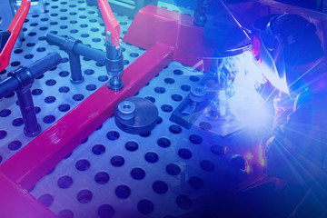 Assembly of metal structures. Welder during work. Welder works next to a special table. Table for...