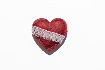 red textured heart on a white background bandaged, the concept of recovery, after illness
