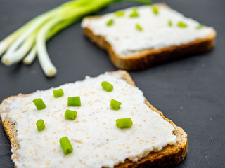 fish roe paste spread on bread slices and green onion on slate breakfast snack concept