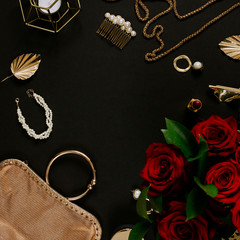 Luxury golden accessories for women's beauty. Dating concept with red lipstick, roses, golden chain, earrings and handbag on black background. Elegant modern template for feminine identity. Flat lay