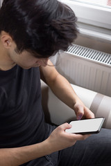 Teenage male student is studying at home, listening to music and surfing the internet.