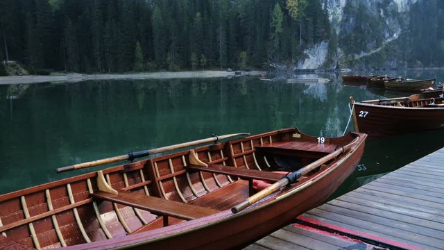 Beautiful landscape of Braies Lake, scenic wooden boats on the water, Alps Mountains Dolomites in Italy.