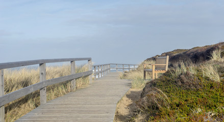 Fototapeta na wymiar seascape of the island of Sylt with bench on a dune off the North Sea coast