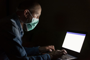 Man wearing mask and working from home in isolation from coronavirus