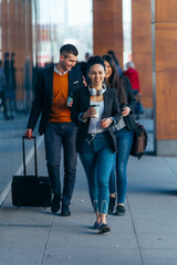 Obraz premium Friends walking together through a modern object while chatting to each other.