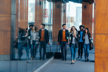 Group of colleagues on a business trip (euro trip) walking together at a modern  futuristic station