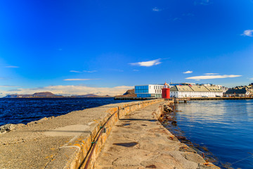 Fototapeta premium AALESUND, NORWAY - 2017 APRIL 27. Red lighthouse at harbor of Alesund.