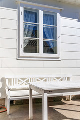 Obraz na płótnie Canvas White house with white outdoors furnitures.