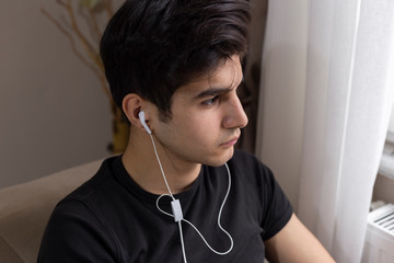 Teenage student studying at home and listening to music