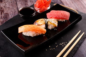 sushi with chopsticks on a black plate