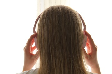 ragazza bionda con cuffie audio di colore rosa 