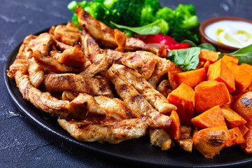 Close-up of grilled chicken breast and vegetables