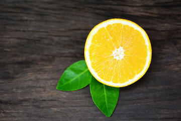 Fototapeta na wymiar Close up fresh orange slice half and orange leaf healthy fruits concept - Orange fruit on wooden background