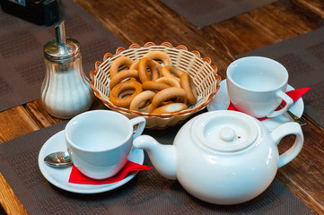 Drying, white cups and a teapot are on the table.
