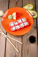 Rolls, wasabi, soy sauce, ginger on the table, avocado.