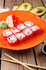 Rolls, wasabi, soy sauce, ginger on the table, avocado.