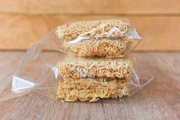 instant noodles in package on wooden background - dry food non perishable storage goods in kitchen home or for donations