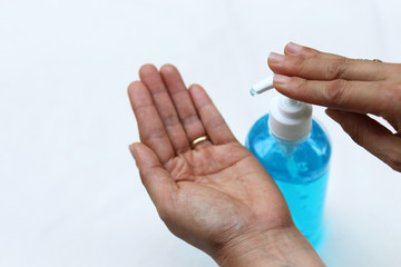 Female fingers pumping alcohol-based hand sanitizer gel on hand for killing germs, bacteria and virus. Disinfection concept of cleaning and washing hands with alcohol sanitizer.
