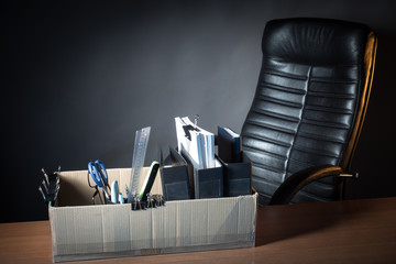 An empty office chair and a box of things on the table. Dismissa