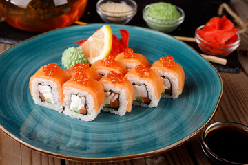 Rolls, wasabi, soy sauce, ginger on the table, avocado.