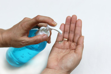 Female fingers pumping alcohol-based hand sanitizer gel on hand for killing germs, bacteria and virus. Disinfection concept of cleaning and washing hands with alcohol sanitizer.