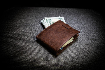 Stylish men's purse with money on wood background.