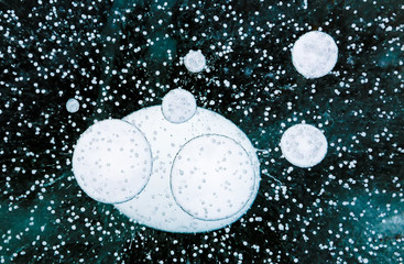 Fototapeta na wymiar Gas bubbles in the ice of a lake Baikal